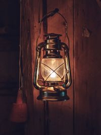 Close-up of illuminated light bulb against wall