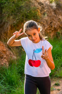 Portrait of girl standing gesturing while standing outdoors