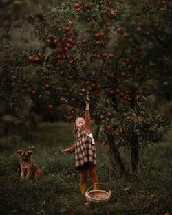 Woman with dog on street amidst trees