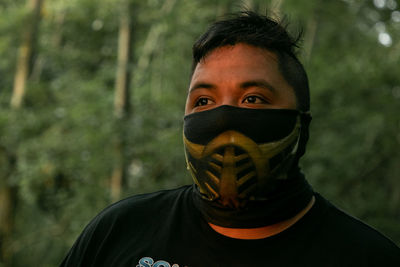 Portrait of young man covering face outdoors
