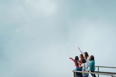 Female friends standing against sky