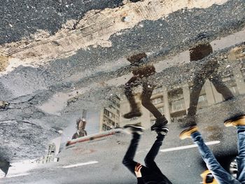 Low section of people walking on road in city