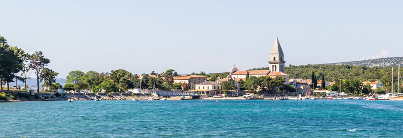 Scenic view of sea by building against clear sky