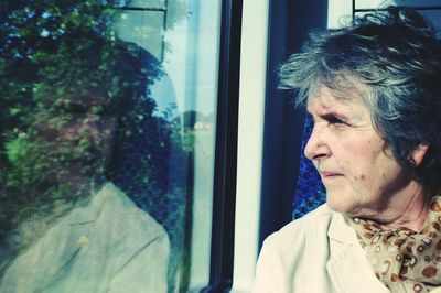 Close-up of woman looking through window