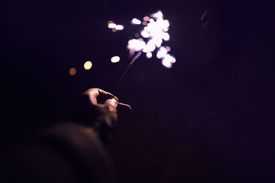 Close-up of hand holding sparkler at night