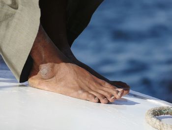 Low section of man sitting on boat in sea