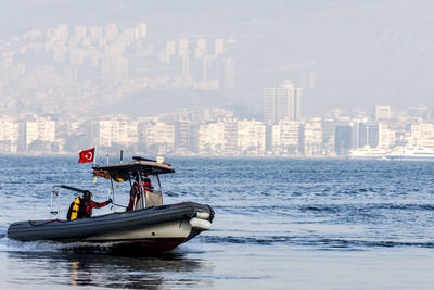 Boat in sea against buildings in city