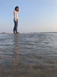 Man standing on beach against clear sky