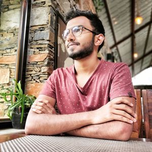 Low angle view of man looking away while sitting by table in restaurant