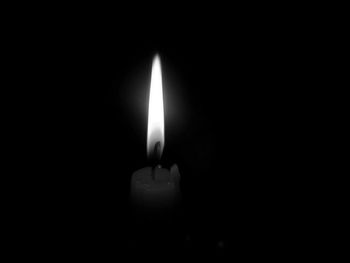 Close-up of lit candle in dark room
