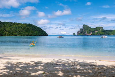 Rear view of woman swimming in sea against sky