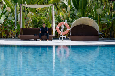 People in swimming pool by plants