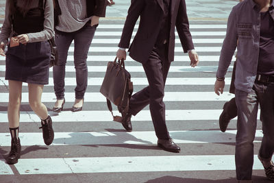 Low section of business people walking on road