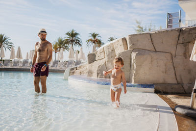 Father and son in paddling pool