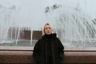 Portrait of a girl against the background of a fountain in the style of the 90s