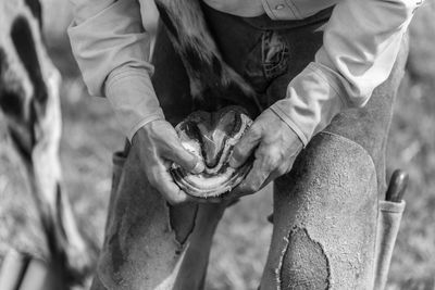 Midsection of man holding horseshoe