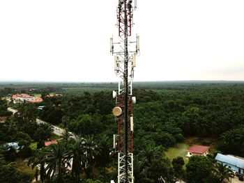 Communications tower on field against clear sky