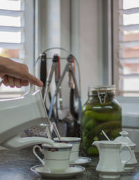 Midsection of person holding tea cup on table