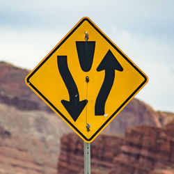 Close-up of arrow sign on road