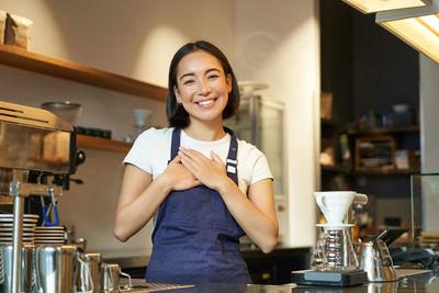 Portrait of young woman standing at home