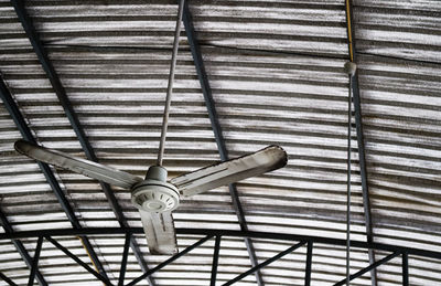 Low angle view of fan hanging on ceiling