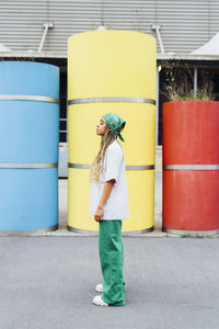 Young woman standing in front of concrete pipes