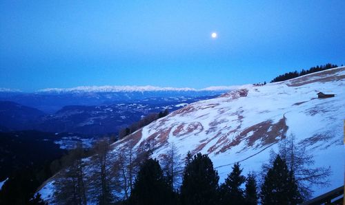 Scenic view of snowcapped mountains against blue sky