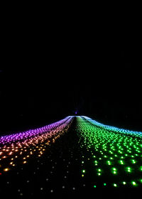 Low angle view of illuminated christmas lights against sky at night