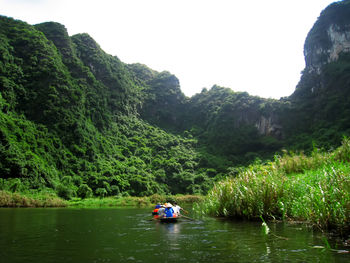 Boat in river against trees