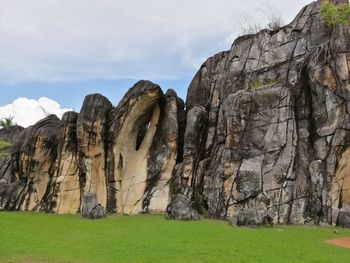 Rock formations on field against sky