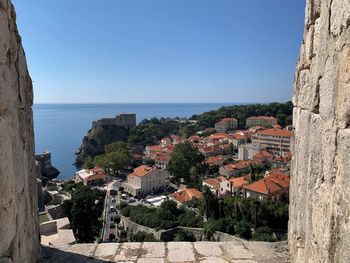 Panoramic view of townscape by sea against clear blue sky