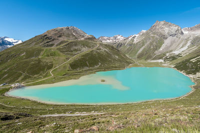 Scenic view of lake and mountains against blue sky