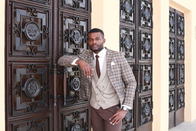 Young man standing at entrance of building