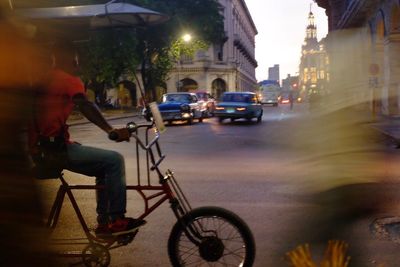 Man riding bicycle on road in city