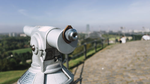 Close-up of coin-operated telescope against sky