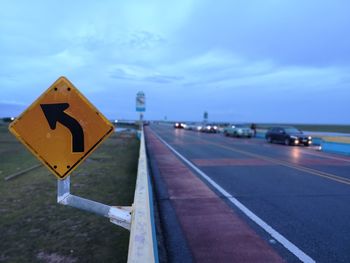 Road sign against sky