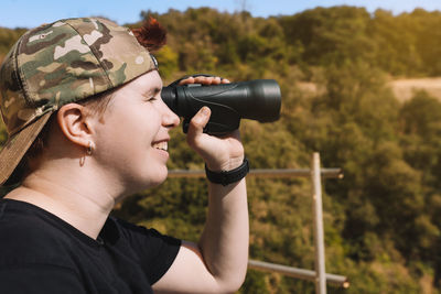 Side view of man photographing through camera