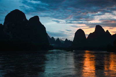 Scenic view of silhouette mountain against sky at sunset