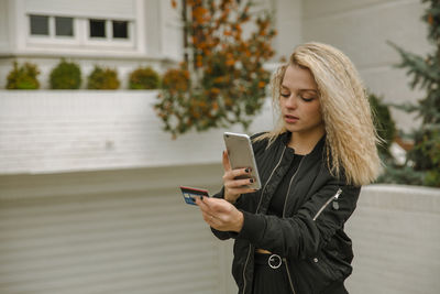 Hipster woman buying online through mobile phone and credit card