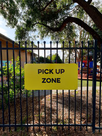 Information sign on fence against trees