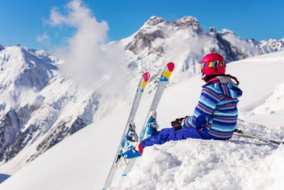 People skiing on snowcapped mountain against sky