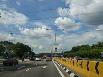 Cars on street against sky