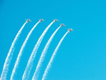 Low angle view of airplane flying against blue sky