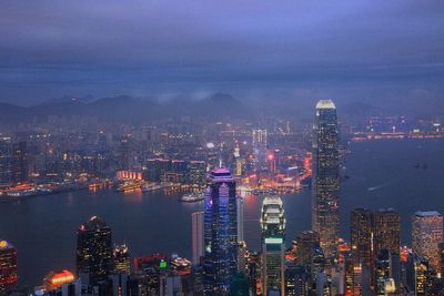 Aerial view of modern illuminated buildings in city at dusk