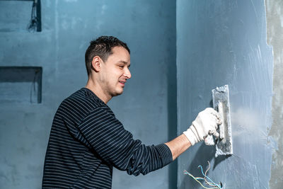 Side view of young man working at construction site