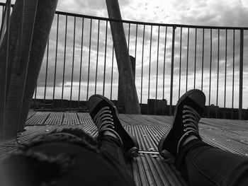 Low section of man relaxing on floor against sky