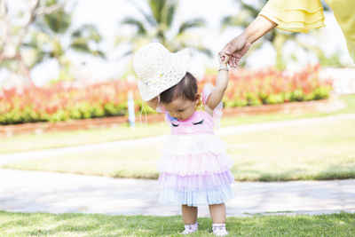 Full length of cute girl standing on plant