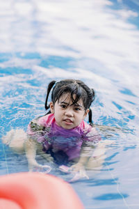 Portrait of young girl swimming in pool