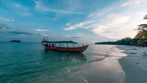 Fishing boat in sea against sky