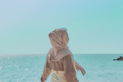 Rear view of woman in sea against clear sky